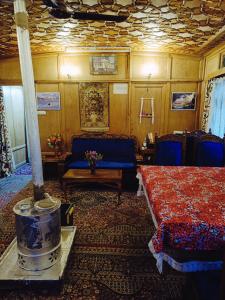 um quarto com uma cama, um sofá e uma mesa em Houseboat New Jeddah em Srinagar