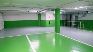 an empty gym with green walls and a tennis court at Morar Ourense in Ourense