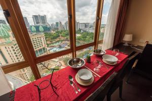 una mesa con platos y cuencos sobre un mantel rojo en 1 - 5pax Lagoon View@ Sunway Resort Suite Pyramid, en Kampong Penaga