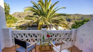 a table and chairs on a balcony with a palm tree at Casa Africa La Taha - Mecina Fondales by Ruralidays in Granada