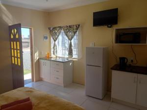 a kitchen with a white refrigerator and a window at Claytons accommodation in Bedford