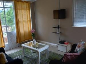 a living room with a table and a window at Claytons accommodation in Bedford