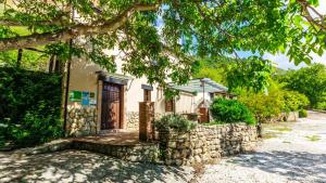 a house with a stone wall and a wooden door at La Huerta del Tajo - Grande Ronda by Ruralidays in Ronda
