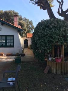 una casa con un árbol y un banco en el patio en Villa refaite à neuf à 200 mètres de la plage en Soulac-sur-Mer