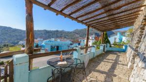 a patio with a table and chairs on a balcony at Los Arrieros Júzcar by Ruralidays in Júzcar