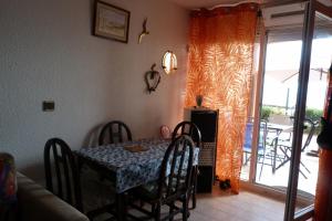 une salle à manger avec une table et des chaises et une fenêtre dans l'établissement La Malosia Résidence Cap Corniche, à Sète 1 autre photo