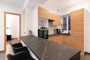 a kitchen with a black counter top and wooden cabinets at LE 23 in Jarny