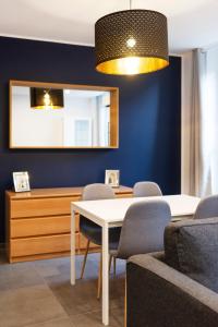 a dining room with a table and chairs and a mirror at LE 23 in Jarny