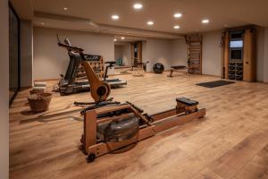 un gimnasio con cinta de correr y equipamiento para hacer ejercicio en una habitación en Theros All Suite Hotel - Adults Only, en Cos