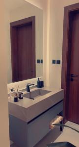 baño con lavabo y espejo grande en روز رزيدنس, en Riad