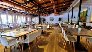 un ristorante con tavoli in legno e sedie bianche di Sunningdale Village Golf Del Sur a San Miguel de Abona