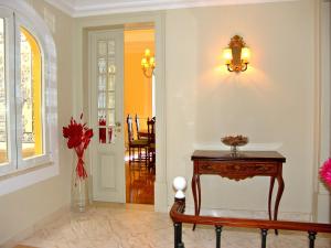 un pasillo con una mesa y un jarrón de flores en Casa do Colegio Velho, en Vila Viçosa