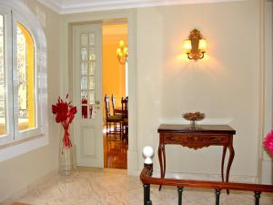 a hallway with a table and a vase of flowers at Casa do Colegio Velho in Vila Viçosa