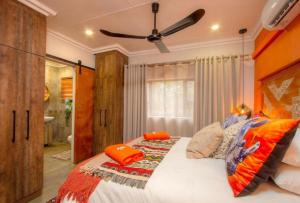 a bedroom with a large bed with orange pillows at Kaya KaBush in Marloth Park