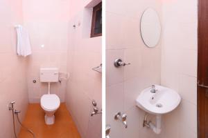 a white bathroom with a toilet and a sink at PPG HOMES in Ernakulam
