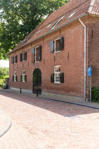 un bâtiment en briques rouges avec une porte et une rue dans l'établissement Hotel Napoleonschuur, à Amerongen