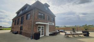 a large brick building with tables and chairs in front of it at Sientjes Boetiekhotel in Kerkdriel