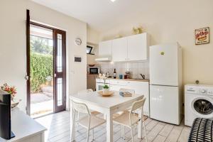 a kitchen with a table and a white refrigerator at Catania Modern Beige Apartment in Catania