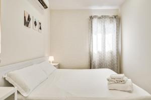 a white bedroom with a white bed and a window at Catania Modern Beige Apartment in Catania