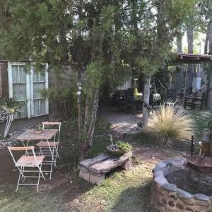 un jardín con mesa, sillas y banco en Mendoza Leisure Time en Chacras de Coria