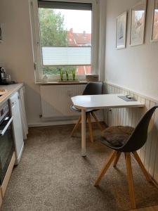 a kitchen with a table and chairs and a window at Ferienwohnung Engelke in Emden