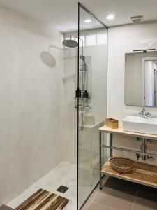 a bathroom with a glass shower and a sink at El Escondite de La Caprichosa in Madrid