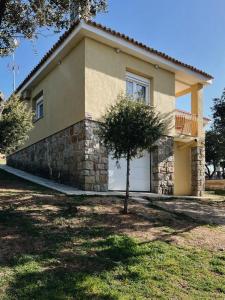 una casa con un árbol delante de ella en El Escondite de La Caprichosa en Madrid