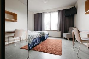 アカスロンポロにあるLapland Hotels Ylläskaltioのベッド、テーブル、鏡が備わる客室です。