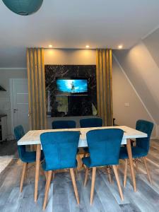 uma sala de conferências com uma mesa e cadeiras e uma televisão em Cabana Green Hill em Borşa