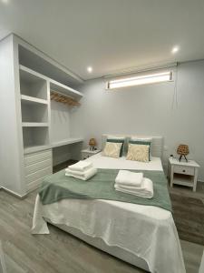 a bedroom with a large bed with towels on it at Apartment Olhão T1 in Olhão +3 photos