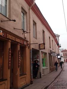 una calle con una tienda al lado de un edificio en Vilnius Old Town accommodation, en Vilna