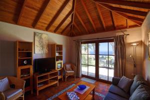 a living room with a couch and a tv at Finca Marina BuenVivir in Tazacorte