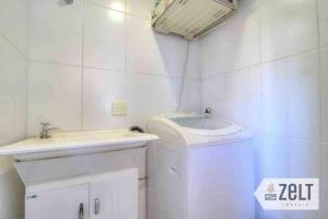 a white bathroom with a sink and a mirror at Conforto à 5 min a pé da Oktoberfest in Blumenau +30 photos