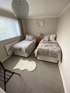 a bedroom with two beds and a heart mirror at Stunning Cottage in Holyhead in Holyhead