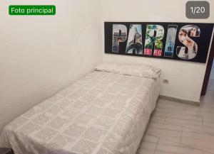 a small bed in a room with posters on the wall at BE LIKE AT HOME PARIS in Alcalá de Henares