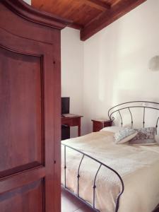 1 dormitorio con 1 cama grande y armario de madera en Agriturismo Pedru Caddu, en Tula