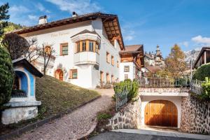 a large white house with a wooden door at Cesa Valeria App Sonia in Ortisei