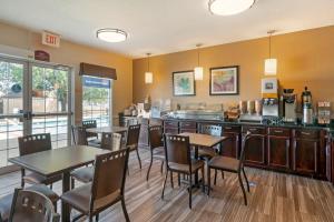 un restaurant avec des tables, des chaises et un comptoir dans l'établissement Best Western Governors Inn and Suites, à Wichita