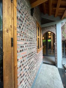 an entrance to a brick wall with a wooden door at Đường lâm village homestay in Yên Vệ +15 photos