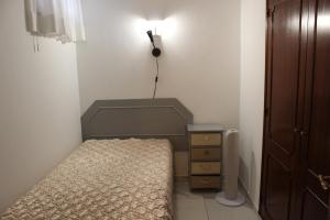 een kleine slaapkamer met een bed en een lamp bij Naturmar Praia in Albufeira