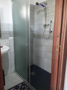a shower with a glass door in a bathroom at Agriturismo Pedru Caddu in Tula