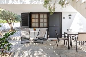 eine Terrasse mit einem Tisch und Stühlen in der Unterkunft Beach Front Vintage Villa Kalliktratis in Nea Kallikratia