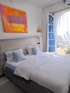 1 cama blanca grande en un dormitorio con ventana en Dolce Vita Palacio, en Douala