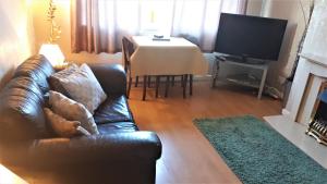 uma sala de estar com um sofá e uma mesa com uma televisão em Picturesque area cosy beds Netflix em Chester