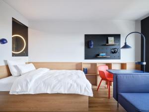 ein Schlafzimmer mit einem Bett, einem Tisch und einem Stuhl in der Unterkunft STAYERY Wolfsburg City in Wolfsburg