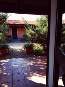 une porte ouverte d'une maison avec une terrasse dans l'établissement Agriturismo Pedru Caddu, à Tula