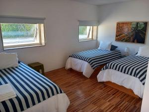 a room with two beds and two windows at HI Vila do Conde - Pousada de Juventude in Vila do Conde