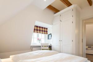 LH Westermüür, App 3 في Braderup: غرفة نوم بيضاء بها سرير ونافذة