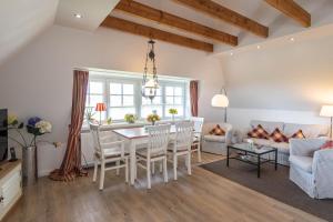 LH Westermüür, App 3 في Braderup: مطبخ وغرفة معيشة مع طاولة وكراسي