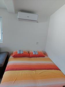 un letto con due cuscini sopra in una stanza di Apartments Tramonto a Bar